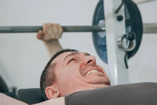Atleet schudt borstspieren in het centrum van de training. oefening borst pers. trainingstools in de Gym close-up — Stockfoto