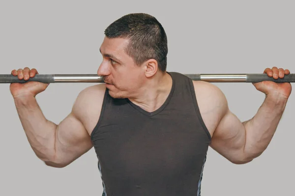 Un atleta bien entrenado entrena los músculos de sus piernas en un centro de entrenamiento. sentadillas de barra en el gimnasio —  Fotos de Stock