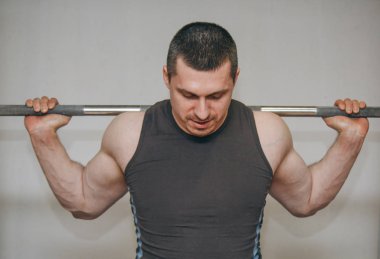İyi eğitimli bir atlet bir eğitim merkezinde bacak kaslarını eğitir. spor salonunda barbell squats