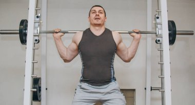 İyi eğitimli bir atlet bir eğitim merkezinde bacak kaslarını eğitir. spor salonunda barbell squats