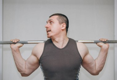 İyi eğitimli bir atlet bir eğitim merkezinde bacak kaslarını eğitir. spor salonunda barbell squats