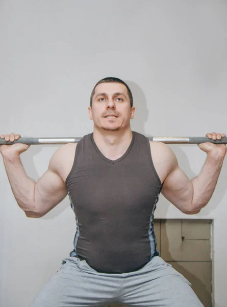 一个训练有素的运动员在训练中心训练他的腿肌肉。杠铃蹲在健身房 — 图库照片