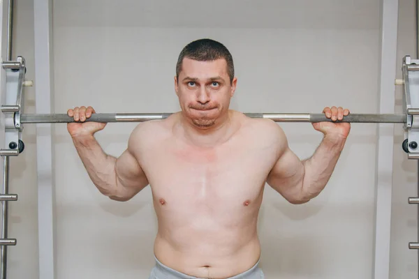 よく訓練されたアスリートは、トレーニングセンターで足の筋肉を訓練します。ジムでバーベルスクワット — ストック写真