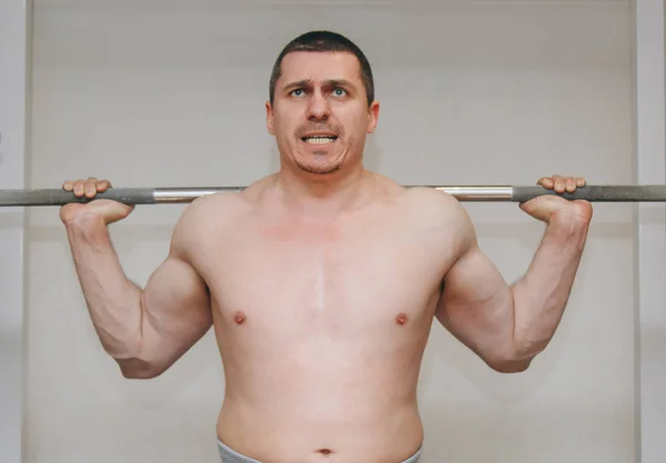 Un atleta bien entrenado entrena los músculos de sus piernas en un centro de entrenamiento. sentadillas de barra en el gimnasio —  Fotos de Stock