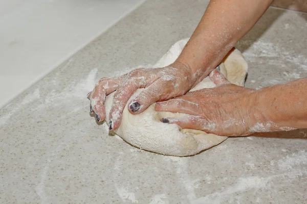 Ženská ruka hnědne těsto na bílou kuchyňskou tabulku. Pohled shora. fáze přípravy na pečení, vaření — Stock fotografie