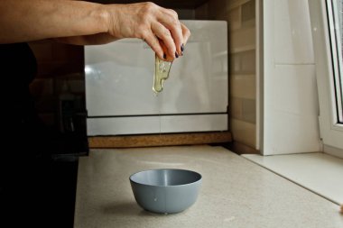 kadın elleri bir tavuk yumurta kırma, bir mutfak iç arka plan karşı bir kase dökme. pişirme, pişirme