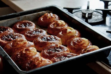 Fırında süzme peynirli taze pişmiş cheesecakes dolu bir tepsi yatıyor. pişirme pişirme. pişirme hazırlık aşaması. Close