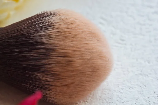 顔をクローズアップに化粧を適用するためのブラシ。マクロの広い柔らかい毛ブラシ — ストック写真