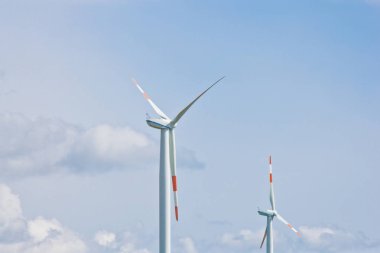 Parlak bulutlu gökyüzünün arka planında rüzgar santrali var. Rüzgar jeneratörü yakın plan. yeşil elektrik, alternatif enerji