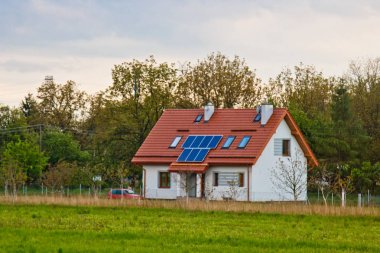 mavi güneşli gökyüzü altında kırsal bir evin çatısında güneş pil. güneş enerjisi, alternatif elektrik