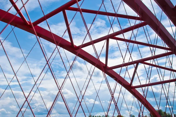 mavi bir gökyüzüne yakın kırmızı kemerli köprü kirişleri. çelik köprü parçalarının kafes doku. diğer tarafa kırpılmış geçiş