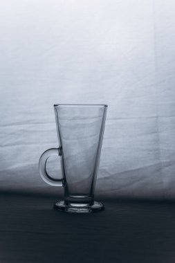 gri gümüş arka plan yakın çekim üzerinde boş şeffaf cam bardak. sapı ve bacak ile yüksek fincan. kopya alanı, doku, arka plan. Dikey