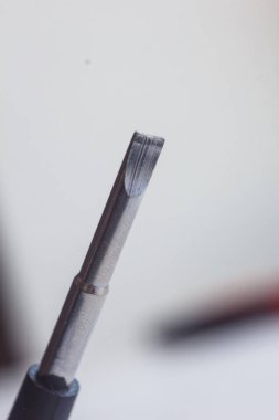 bulanık bir arka plan üzerinde metal düz tornavida yakın çekim başkanı. el aleti kapatın. kopya alanı. Dikey