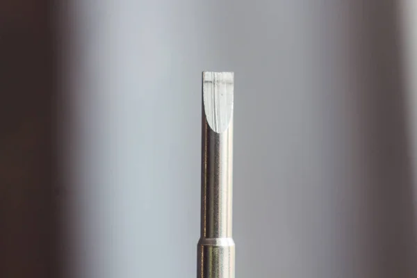 Cabeça de uma chave de fenda plana de metal close-up em um fundo borrado. ferramenta de mão de perto. espaço de cópia — Fotografia de Stock