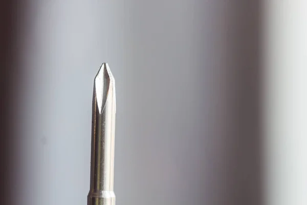Cabeça de metal cruzes chave de fenda close-up em um fundo borrado. ferramenta de mão de perto. espaço de cópia — Fotografia de Stock
