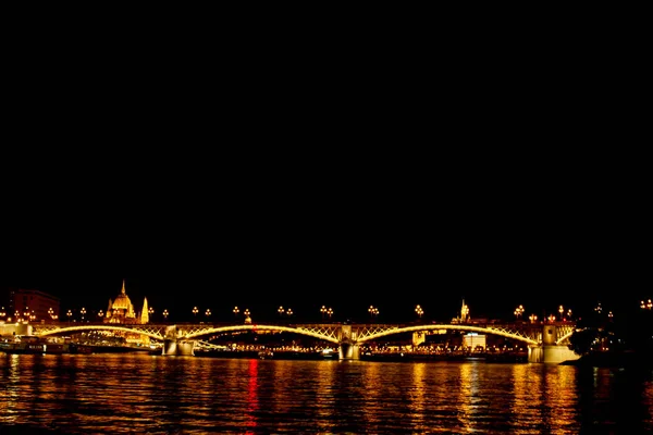 Noite Budapeste, brilhando em ouro. A ponte sobre o Danúbio é iluminada por lâmpadas. foto do rio — Fotografia de Stock