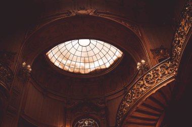vintage korkuluk kapalı eski spiral ahşap merdiven. aristokrat bir saray salonunda lüks oyma ahşap iç. cam kubbe tavanlı nadir mimari. kopyalama alanı