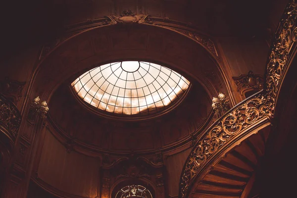 vintage korkuluk kapalı eski spiral ahşap merdiven. aristokrat bir saray salonunda lüks oyma ahşap iç. cam kubbe tavanlı nadir mimari. kopyalama alanı