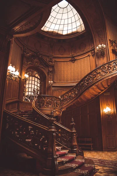 屋内でヴィンテージ手すりと古い螺旋状の木製の階段。貴族の宮殿のホールで豪華な彫刻木製のインテリア。ガラスドーム天井の珍しい建築。コピースペース — ストック写真