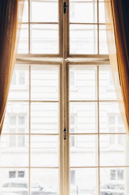 Güneşli bir günde eski perdeleri ve kare perdeleri olan ahşap bir pencere. bej saten perdeler. İç mekan. kolaj için arkaplan