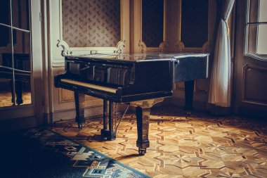 Siyah klasik kuyruklu piyano, güneş ışığı altındaki bir pencerenin yanında lüks bir odanın ortasında yer almaktadır. klasik müzik aleti, barok iç