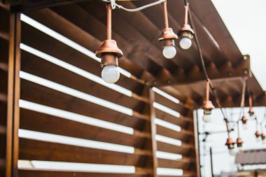 Beyaz ampuller bir çelenk evin soylu çatı üzerinde asılı. komşu ve gökyüzüne bakan evin üstünde ahşap çardak. Penthouse