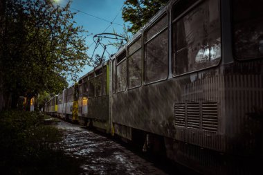 eski tramvaylar bir satır açık bir gökyüzünün arka planına karşı parkta tek tek durmak. toplu taşıma gözlük üzerinde yansıması. demiryolu taşımacılığı haddeleme stok reklam