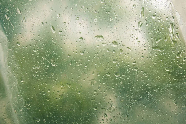半透明、雾化玻璃上的水滴。春雨落在雾窗上。模糊的背景复制空间 — 图库照片