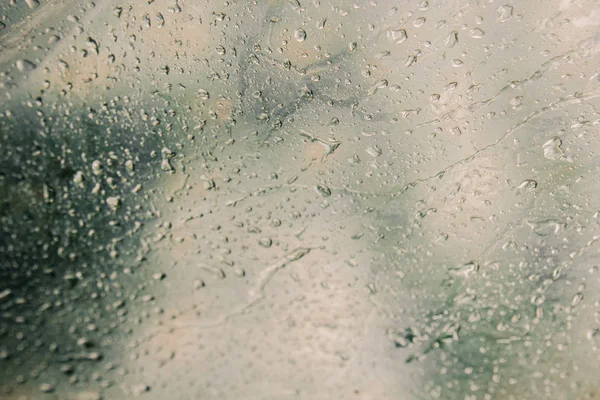 water droplets on translucent, misted glass. Spring rain drops on fogged window close up. blurred background copy space