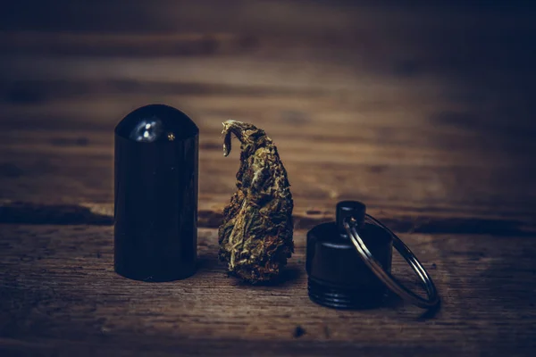 Αποθήκευση κώνους κάνναβης σε ένα δοχείο μπρελόκ με τη μορφή μιας σφαίρας κοντινό. μεταφορά και αποθήκευση νομιμοποιώντας μαλακό φάρμακο στην τσέπη — Φωτογραφία Αρχείου