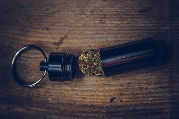 Storing cannabis cones in a keychain container in the form of a bullet close-up. carrying and storing legalized soft drug in pocket crisper — Stock Photo, Image