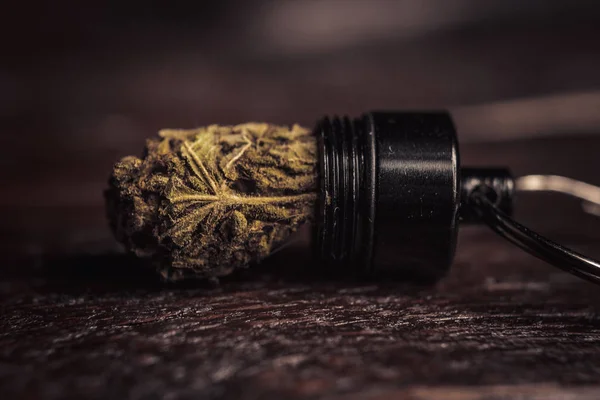 Armazenar cones de cannabis em um recipiente de chaveiro na forma de um close-up de bala. transporte e armazenamento de drogas leves legalizadas no bolso mais nítido — Fotografia de Stock