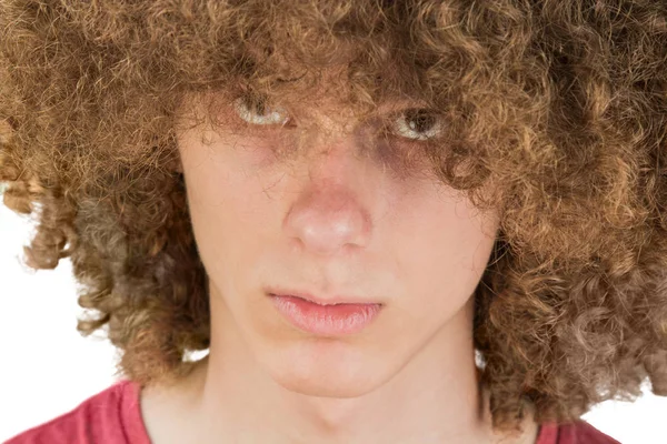 Portrait of a young curly European man with a serious look looking at his long hair with his eyes up. very lush male guy hair. curling hair for men. isolated on white background — Stock Photo, Image