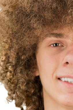 uzun kıvırcık saçlı ve rüya gibi bir gülümseme yakın çekim ile genç bir kıvırcık Avrupalı adamın yarı kırpılmış portre bölünmüş. çok gür erkek saçı. kıvırma saç erkekler. bir tutku kilidi. beyaz arka plan üzerinde izole