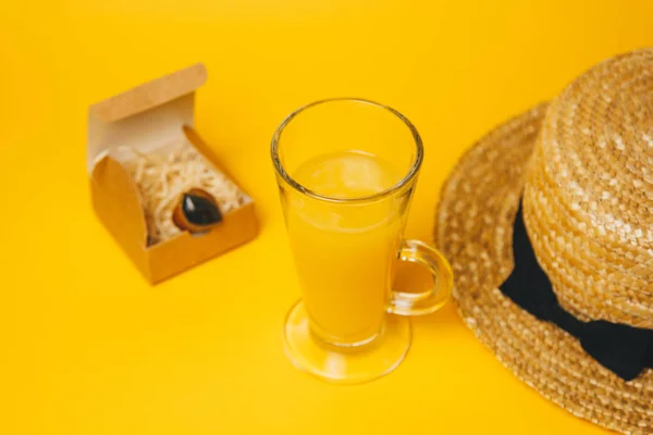 Концепция отдыха и жажды на пляже. стакан лимонада на желтом фоне с соломенной шляпой. вид сверху — стоковое фото