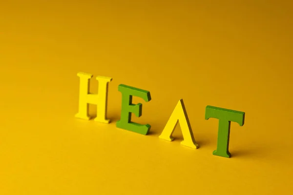 Wärmeschutzkonzept am Strand. Inschrift Hitze auf gelbem Hintergrund. Ansicht von oben — Stockfoto