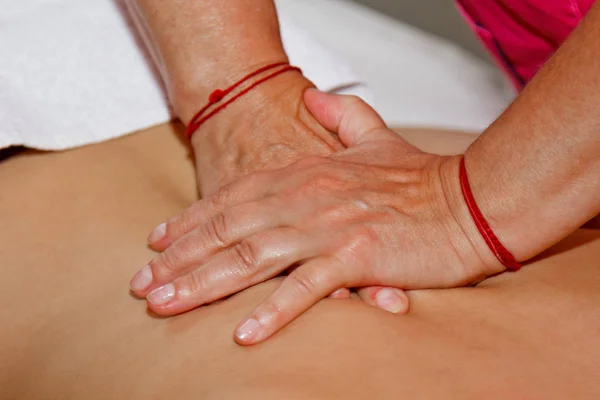 Professional therapeutic massage of the back and neck. woman doctor massages girl athlete in a massage room. body and health care. procedure for recovery from pain after sports workouts — Stock Photo, Image