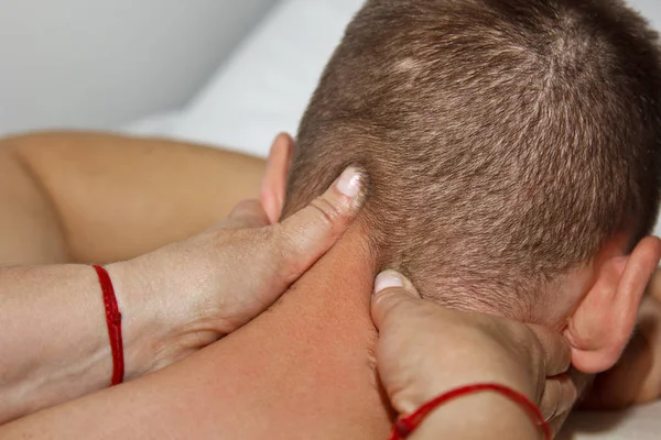 Massagem médica profissional da cabeça e pescoço. mulher médico massagens um homem atleta em uma sala de massagem. corpo e cuidados de saúde. procedimento para recuperação da dor após exercícios esportivos — Fotografia de Stock