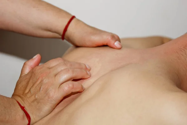 Massagem terapêutica profissional das costas e pescoço. mulher médico massagens um homem atleta em uma sala de massagem. corpo e cuidados de saúde. procedimento para recuperação da dor após exercícios esportivos — Fotografia de Stock