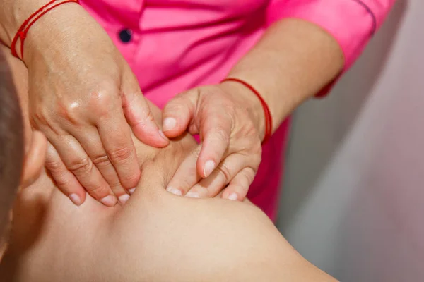 Masaje terapéutico profesional en hombros y cuello. doctora masajea a un atleta en una sala de masajes. cuidado del cuerpo y de la salud. procedimiento para la recuperación del dolor después de los entrenamientos deportivos —  Fotos de Stock