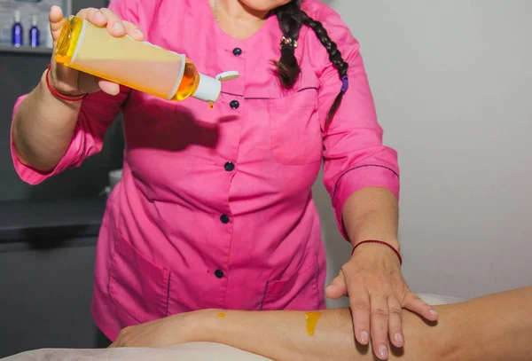 Professionelle therapeutische Handmassage mit Massageöl. Ärztin massiert einen männlichen Sportler in einem Massageraum. Körper- und Gesundheitsversorgung. Verfahren zur Genesung von Schmerzen nach Sport-Workouts — Stockfoto