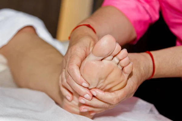 Massaggio ai piedi terapeutico professionale. Il dottore donna massaggia l'atleta in una sala massaggi. corpo e assistenza sanitaria. procedura di recupero del dolore — Foto Stock