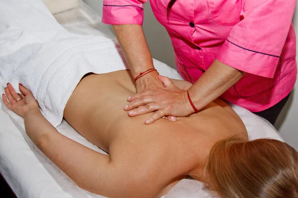 Professionelle therapeutische Rückenmassage. Ärztin massiert Mädchen die Athletin in einem Massageraum. Körper- und Gesundheitsversorgung. Verfahren zur Schmerzbehandlung — Stockfoto