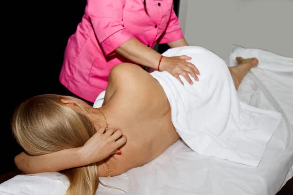 Profesionální terapeutická masáž. holku v masážní místnosti. tělesné a zdravotní péče. postup zotavení po bolesti. Ženská fyzioterapeutka na mladého pacienta s manipulativním páteří — Stock fotografie