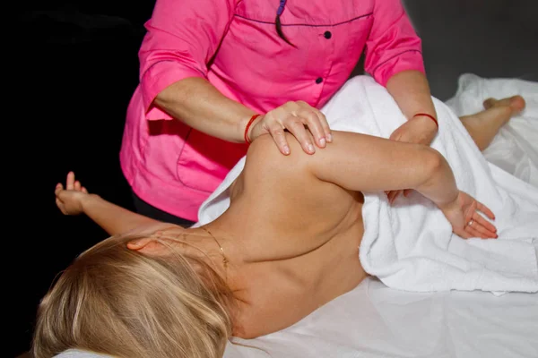 Profesyonel terapötik masaj. kız bir masaj odasında atlet. vücut ve sağlık hizmetleri. ağrı kurtarma prosedürü. Genç hasta üzerinde manipülatif omurga tedavisi yapan kadın fizyoterapist — Stok fotoğraf