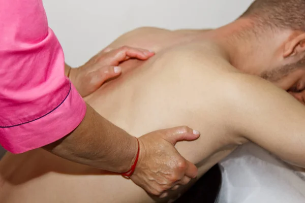 Profesjonalną leczniczą szyję i masaż głowy. człowieka sportowca w gabinecie masażu. procedury odzyskiwania bólu. Kobieta fizjoterapeuta robi manipulacyjne leczenie kręgosłupa na młodego pacjenta — Zdjęcie stockowe