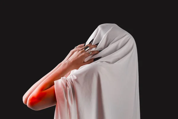 A woman covered with white cloth with a closed face suffers. faceless pain. long black nails on thin female fingers. emotion without facial expressions — Stock Photo, Image