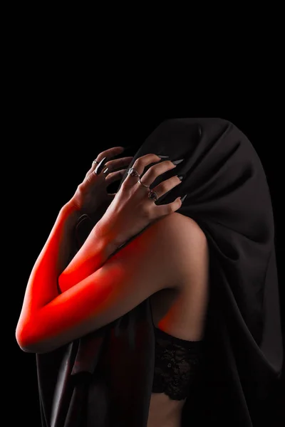 Uma mulher coberta com um pano preto com um rosto fechado sofre. dor sem rosto. unhas pretas longas em dedos femininos finos. emoção sem expressões faciais — Fotografia de Stock