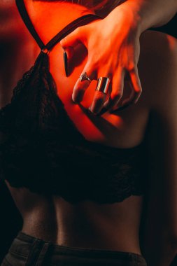 Uzun tırnakları ile Kadın elleri izole siyah bir arka plan üzerinde ince bir ihale savunmasız kadın vücudu sarılmak. kendinden nefret kavramı. parmaklarda gümüş halkalar. dantel sütyen seksi ince kız