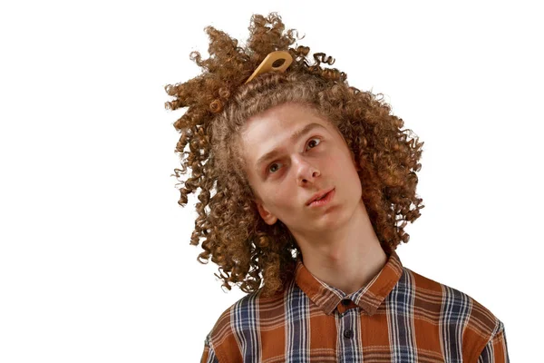 Retrato de um jovem de cabelos encaracolados com um pente de madeira no cabelo cheio sorrindo em um fundo isolado branco. conceito de cuidado do cabelo masculino — Fotografia de Stock